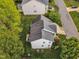 Aerial view of a white home with a gray roof, back deck, lawn, and green foliage at 3236 Forest Mill Cir, Raleigh, NC 27616