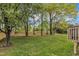 Large, tree-lined backyard with a grassy lawn and partially fenced perimeter at 3236 Forest Mill Cir, Raleigh, NC 27616