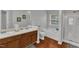 Bathroom featuring double sinks, a soaking tub, separate shower, and wood-look flooring at 3236 Forest Mill Cir, Raleigh, NC 27616