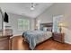 A well-lit main bedroom featuring a ceiling fan, hardwood floors, and large windows at 3236 Forest Mill Cir, Raleigh, NC 27616