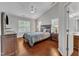 Comfortable main bedroom features a ceiling fan, hardwood floors, and large windows for plenty of natural light at 3236 Forest Mill Cir, Raleigh, NC 27616