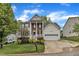 Charming two-story home with white siding, brick accents, a two car garage, and lush landscaping at 3236 Forest Mill Cir, Raleigh, NC 27616
