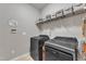 Functional laundry room with washer, dryer, shelving and tile floors at 3236 Forest Mill Cir, Raleigh, NC 27616