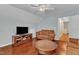 Comfortable living room featuring wood floors, a couch, and an entertainment center with television at 3236 Forest Mill Cir, Raleigh, NC 27616