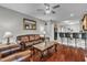 Cozy living room featuring a leather sofa, hardwood floors, and open access to the kitchen at 3236 Forest Mill Cir, Raleigh, NC 27616