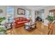 Bright, comfortable living room offering hardwood floors, a red leather sofa, and great natural light at 3236 Forest Mill Cir, Raleigh, NC 27616