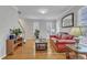 Inviting living room with hardwood floors, a red leather sofa, and natural light from the windows at 3236 Forest Mill Cir, Raleigh, NC 27616