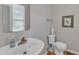 Cozy powder room featuring a pedestal sink and a modern toilet at 3236 Forest Mill Cir, Raleigh, NC 27616