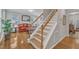 Bright staircase featuring hardwood floors and wooden handrails leads to the upper level of the house at 3236 Forest Mill Cir, Raleigh, NC 27616
