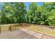 A wooden back deck provides an excellent view of the treed backyard, perfect for enjoying a quiet afternoon at 7039 Old 421 Rd, Liberty, NC 27298