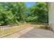 A wooden back deck provides an excellent view of the treed backyard, perfect for enjoying a quiet afternoon at 7039 Old 421 Rd, Liberty, NC 27298