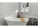 Bright bathroom featuring a soaking tub with marble tile surround, and orchids for an elegant design at 7039 Old 421 Rd, Liberty, NC 27298