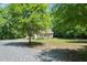 A serene property featuring a home nestled among lush trees, gravel driveway, and expansive yard at 7039 Old 421 Rd, Liberty, NC 27298