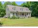 A charming two-story home featuring a front porch, complemented by a well-maintained lawn at 7039 Old 421 Rd, Liberty, NC 27298
