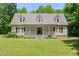 Inviting home with a charming front porch, manicured lawn, dormer windows and mature trees at 7039 Old 421 Rd, Liberty, NC 27298