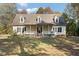Charming home featuring a welcoming front porch, dormer windows and mature trees at 7039 Old 421 Rd, Liberty, NC 27298