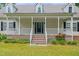 Home with a charming front porch and steps, enhanced by flower landscaping at 7039 Old 421 Rd, Liberty, NC 27298