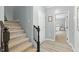 Hallway with stairs, gray walls, view to carpeted bedroom and plank flooring at 7039 Old 421 Rd, Liberty, NC 27298