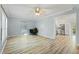 Light-filled living room featuring hardwood floors, a ceiling fan, and a view to the kitchen at 7039 Old 421 Rd, Liberty, NC 27298