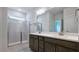 Bathroom showcasing a walk-in shower, a double sink vanity, and gray cabinets at 7529 Percussion Dr, Apex, NC 27539