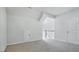 Bright bedroom with neutral carpet and walls and access to the upper level of the house at 7529 Percussion Dr, Apex, NC 27539