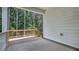 Image shows a covered patio with wooden railing, wood deck and forest in the background at 7529 Percussion Dr, Apex, NC 27539