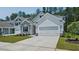 Charming home showcasing stone accents, white siding, two-car garage and well-maintained landscaping at 7529 Percussion Dr, Apex, NC 27539