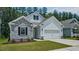 Beautiful home featuring stone accents, white siding, a two-car garage, and attractive landscaping at 7529 Percussion Dr, Apex, NC 27539