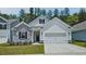 Charming home featuring stone accents, white siding, a two-car garage, and well-manicured lawn at 7529 Percussion Dr, Apex, NC 27539