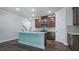 Modern kitchen with a large island, stainless steel appliances, tile backsplash, and dark brown cabinets at 7529 Percussion Dr, Apex, NC 27539