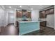 Modern kitchen featuring stainless steel appliances, an island with quartz countertops, and wood floors at 7529 Percussion Dr, Apex, NC 27539