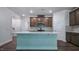 Modern kitchen with a large island, stainless steel appliances, tile backsplash, and dark brown cabinets at 7529 Percussion Dr, Apex, NC 27539