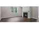 Living room with a large window overlooking the backyard and a traditional fireplace at 7529 Percussion Dr, Apex, NC 27539