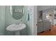 Powder room featuring a white pedestal sink, oval mirror, and light green paint at 1120 Renewal Place # 108, Raleigh, NC 27603