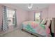 Charming bedroom with pink walls, two windows, a patterned quilt and a ceiling fan at 1120 Renewal Place # 108, Raleigh, NC 27603