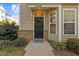 Well-maintained townhouse entrance featuring a decorative wreath, lush plants, and brick accents at 1120 Renewal Place # 108, Raleigh, NC 27603