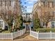Neighborhood street with neatly kept lawns and white picket fences dividing charming townhouse properties at 1120 Renewal Place # 108, Raleigh, NC 27603