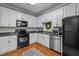 Bright kitchen featuring white cabinets, stainless steel appliances, and hardwood floors at 1120 Renewal Place # 108, Raleigh, NC 27603