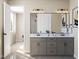 Spacious bathroom with dual sinks, sleek cabinets, a framed mirror, and a tile shower in the background at 1204 Holding Village Way, Wake Forest, NC 27587