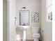 Well-lit powder room with modern fixtures, a pedestal sink, and a decorative mirror to compliment the decor at 1204 Holding Village Way, Wake Forest, NC 27587
