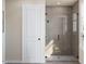 Modern bathroom features a frameless glass shower with gray tile surround, white door, and a large towel rack at 1204 Holding Village Way, Wake Forest, NC 27587
