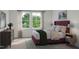 Serene bedroom featuring two large windows with a view, a plush bed, and sophisticated decor at 1204 Holding Village Way, Wake Forest, NC 27587