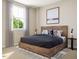 Relaxing bedroom with a rustic wood bed frame, large window, and a cozy rug for a comfortable setting at 1204 Holding Village Way, Wake Forest, NC 27587