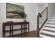 Chic entryway with a wooden console table, a decorative plant, and modern staircase with black metal railings at 1204 Holding Village Way, Wake Forest, NC 27587