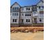 Unfinished exterior showcasing the building's framework with multiple windows and Tyvek HomeWrap at 1204 Holding Village Way, Wake Forest, NC 27587