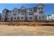 Unfinished exterior showcasing the building's framework with multiple windows and Tyvek HomeWrap at 1204 Holding Village Way, Wake Forest, NC 27587