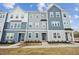 Charming townhomes featuring varied blue and gray tones, accented by white trim and lush landscaping at 1204 Holding Village Way, Wake Forest, NC 27587