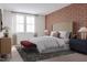 Bedroom featuring a decorative accent wall, large window and a padded bench at the foot of the bed at 1204 Holding Village Way, Wake Forest, NC 27587