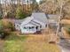 Aerial view of a charming single-story home with a welcoming front porch, gray siding, and a private driveway at 135 Weatherbend, Pittsboro, NC 27312