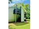 Rear exterior view featuring a balcony and staircase surrounded by mature trees and a well-maintained lawn at 135 Weatherbend, Pittsboro, NC 27312
